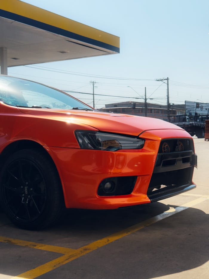 services-02 A striking red car parked at a sunny Brazilian gas station in São Paulo, Brazil.